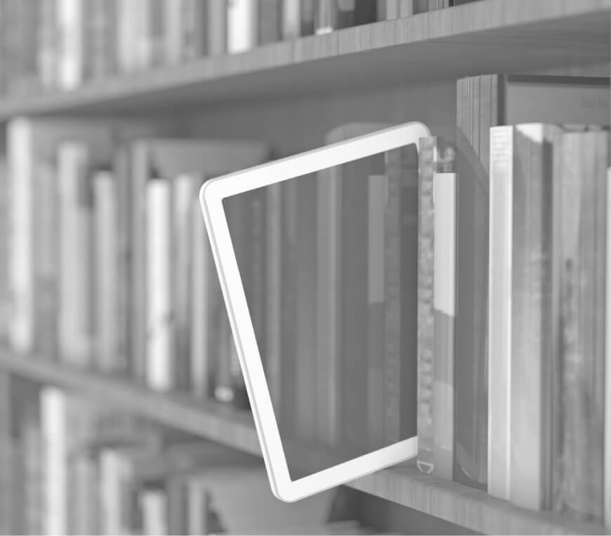 Tablet inserted between books on a library shelf.